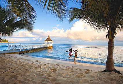 Kids jumping on the beach at Half Moon Resort