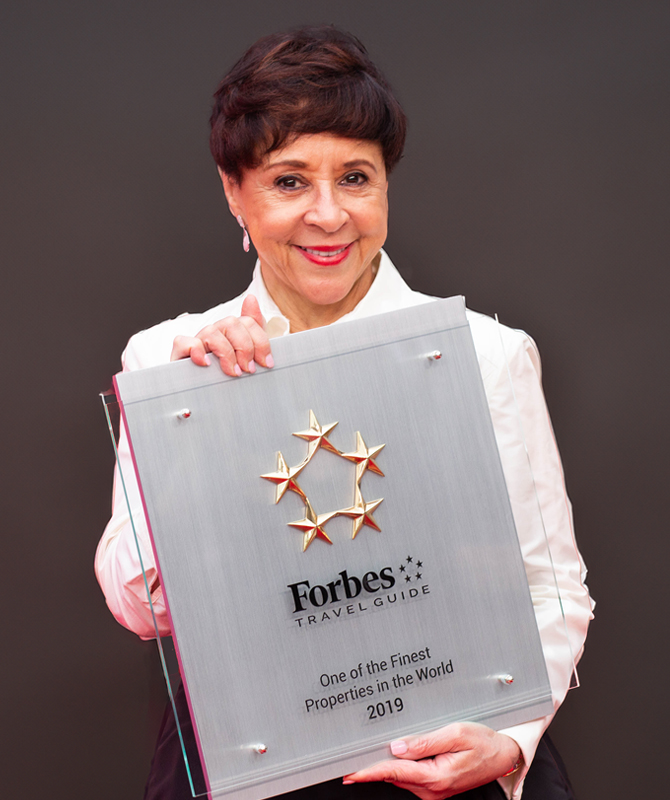 Sheila holding a Forbes Award